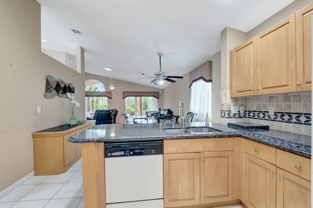 kitchen featuring kitchen peninsula, tasteful backsplash, white dishwasher, vaulted ceiling, and sink