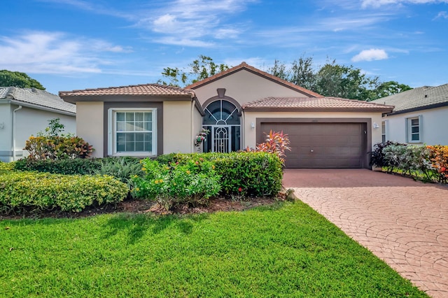 mediterranean / spanish-style home with a front lawn and a garage