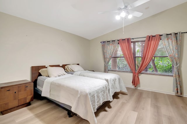 bedroom with ceiling fan, lofted ceiling, and light hardwood / wood-style floors