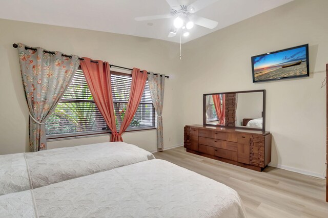 bedroom featuring ceiling fan, lofted ceiling, and light hardwood / wood-style floors