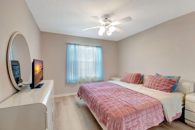 bedroom with ceiling fan and light hardwood / wood-style flooring