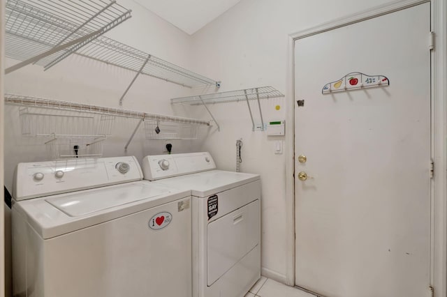 laundry room featuring separate washer and dryer and light tile patterned flooring