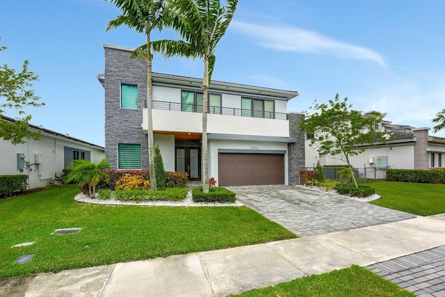 contemporary home featuring a front lawn, a garage, and a balcony