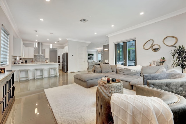 living room with sink, light tile patterned floors, and crown molding