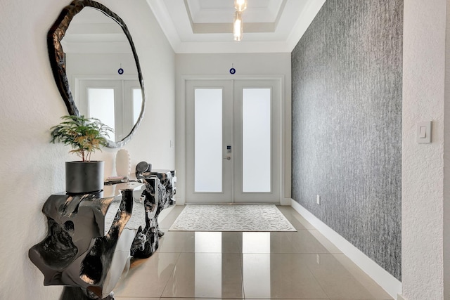 tiled foyer with french doors and a raised ceiling