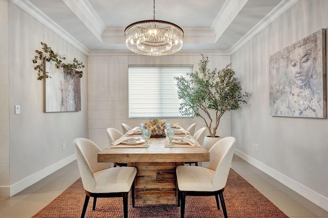 tiled dining space with crown molding, a chandelier, and a raised ceiling