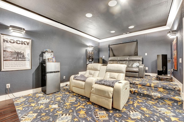 cinema room featuring a textured ceiling, hardwood / wood-style flooring, and crown molding