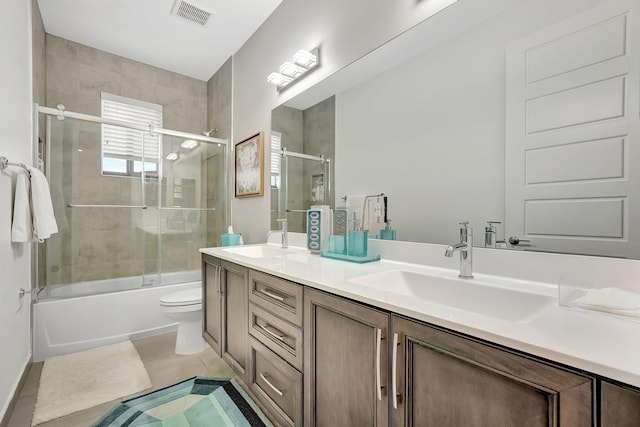 full bathroom featuring shower / bath combination with glass door, tile patterned floors, vanity, and toilet