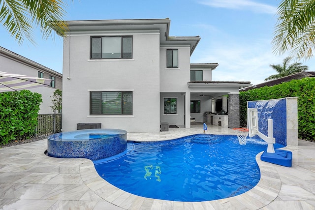 view of swimming pool with a patio area, pool water feature, and an in ground hot tub