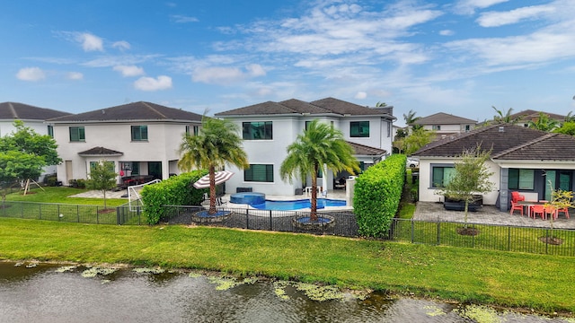 back of property featuring a fenced in pool, a water view, a yard, and a patio area