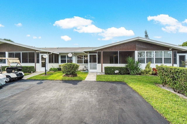 view of front of property featuring a front yard and a sunroom