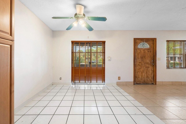 unfurnished room featuring light tile patterned floors, a textured ceiling, and ceiling fan