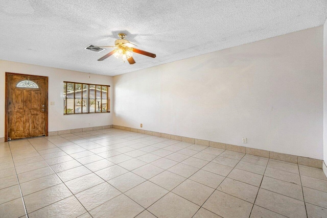 unfurnished room featuring a textured ceiling, ceiling fan, and light tile patterned flooring