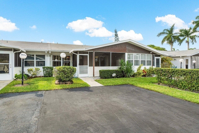 exterior space featuring a sunroom and a front lawn