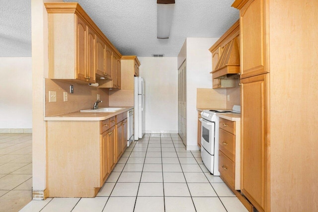 kitchen with decorative backsplash, sink, light tile patterned floors, and white appliances