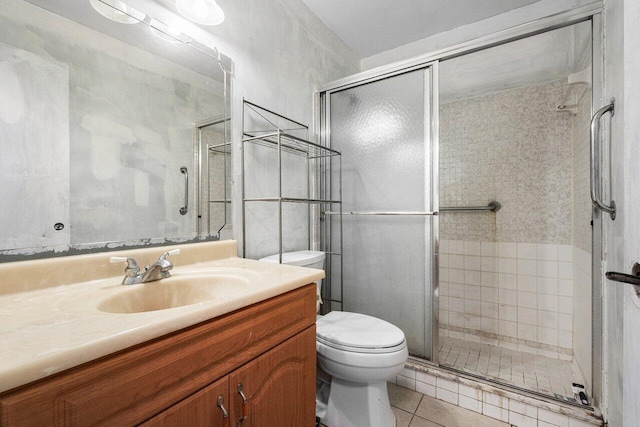 bathroom featuring tile patterned floors, vanity, toilet, and walk in shower