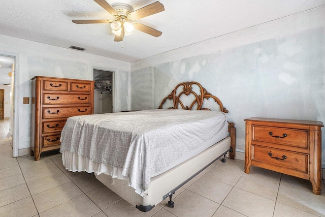 bedroom featuring a walk in closet, ceiling fan, a closet, and light tile patterned flooring