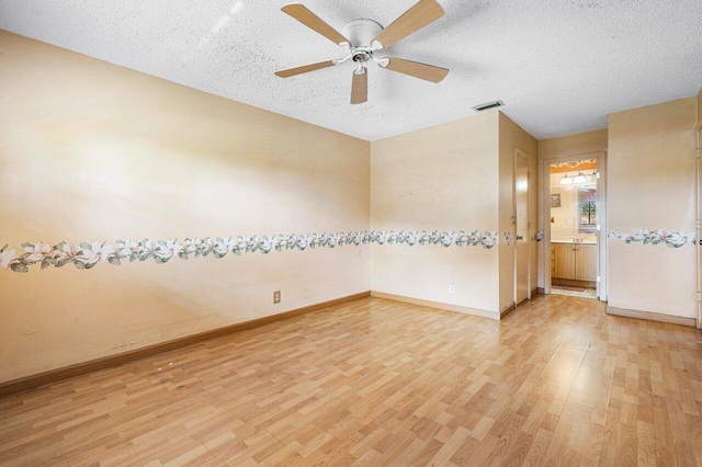 empty room featuring hardwood / wood-style floors, ceiling fan, and a textured ceiling