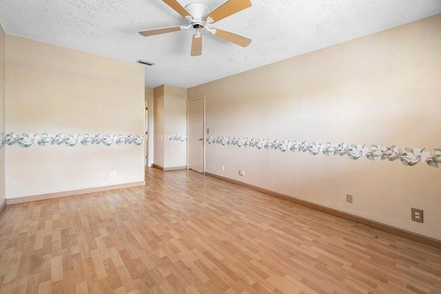 empty room featuring a textured ceiling, light hardwood / wood-style flooring, and ceiling fan