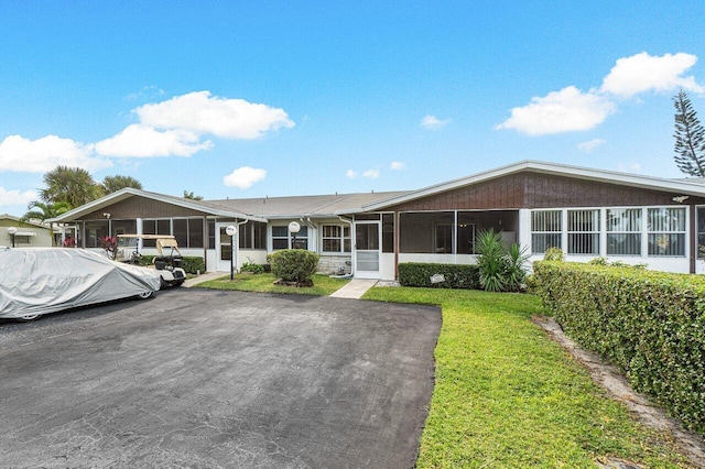 view of front of property with a sunroom and a front lawn