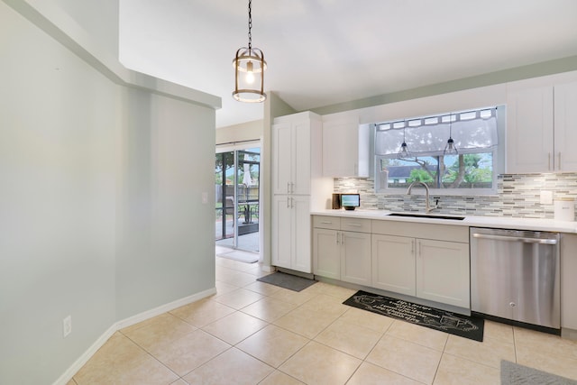 kitchen with stainless steel dishwasher, a wealth of natural light, white cabinetry, and decorative backsplash