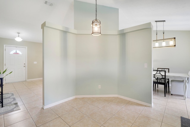 unfurnished dining area featuring light tile patterned floors and vaulted ceiling