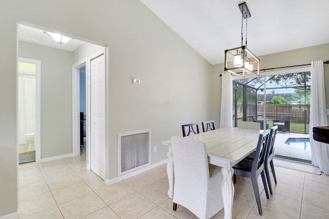 tiled dining room featuring vaulted ceiling