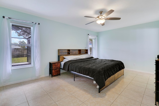 bedroom featuring ceiling fan, multiple windows, and light tile patterned floors