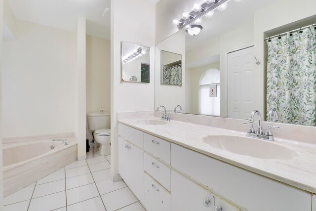 bathroom with a relaxing tiled tub, tile patterned flooring, toilet, and vanity