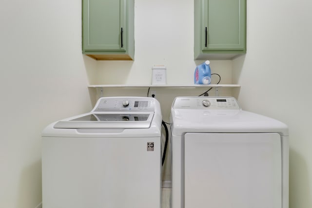 washroom with separate washer and dryer and cabinets