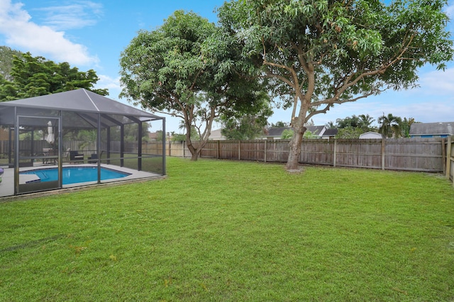 view of yard with glass enclosure and a fenced in pool