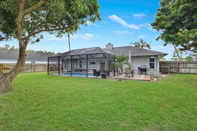 back of property with a yard, a patio, a fenced in pool, and glass enclosure