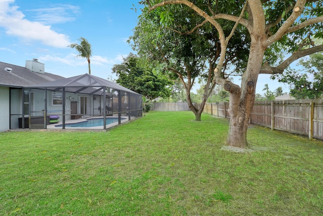 view of yard featuring a fenced in pool and glass enclosure