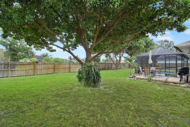 view of yard with a lanai, a patio, and a fenced in pool