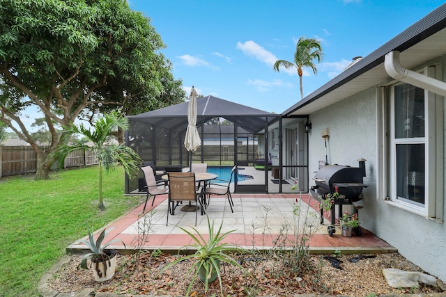 view of patio / terrace with a fenced in pool, a grill, and glass enclosure