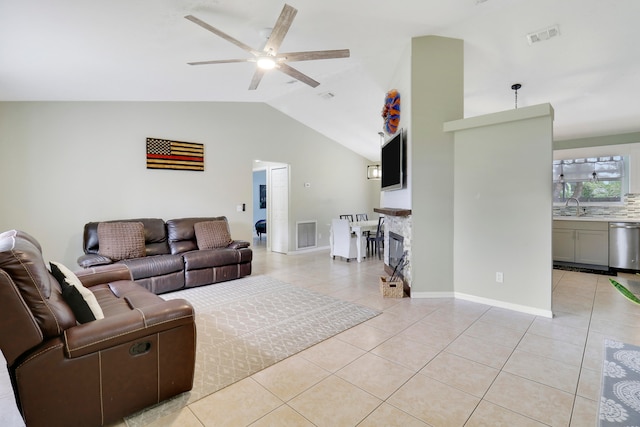 living room with lofted ceiling, sink, light tile patterned floors, and ceiling fan