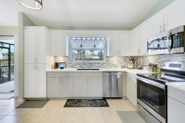 kitchen featuring white cabinetry, stainless steel appliances, light tile patterned flooring, and sink