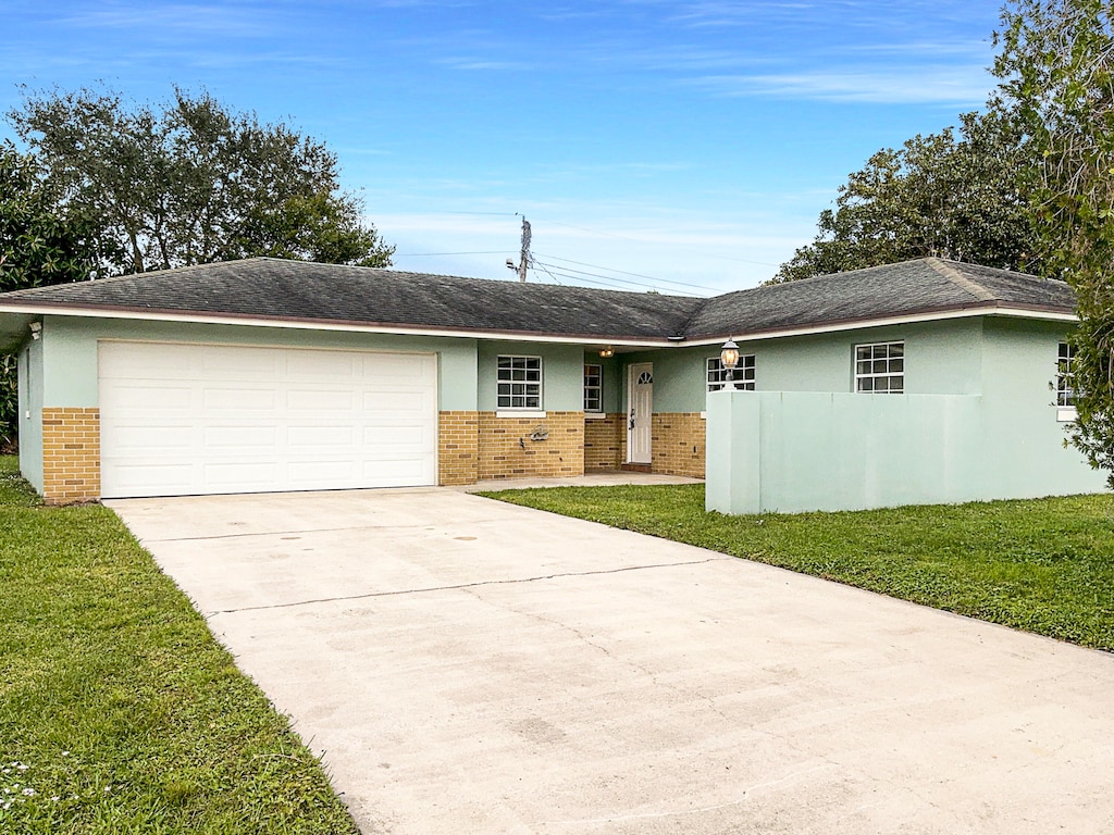 ranch-style house with a garage and a front yard