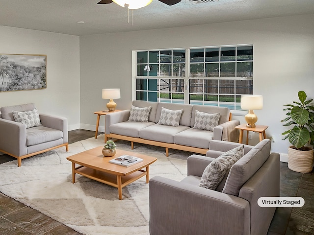 living room featuring a textured ceiling, wood-type flooring, and ceiling fan