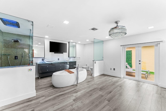 bathroom featuring double vanity, an enclosed shower, wood finished floors, and french doors