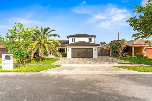 view of front of property featuring decorative driveway, stucco siding, a front yard, fence, and a garage