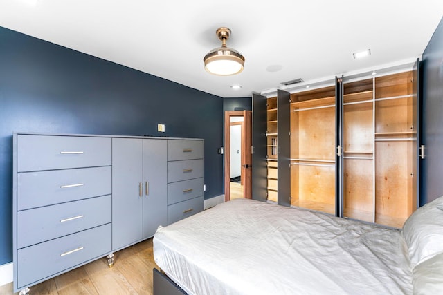 bedroom featuring light wood finished floors, a closet, and visible vents