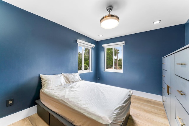 bedroom with light wood-style floors and baseboards