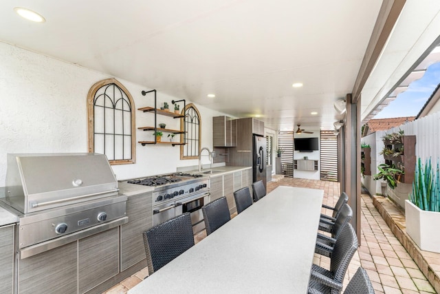 view of patio / terrace featuring outdoor dining area, a grill, an outdoor kitchen, and a sink