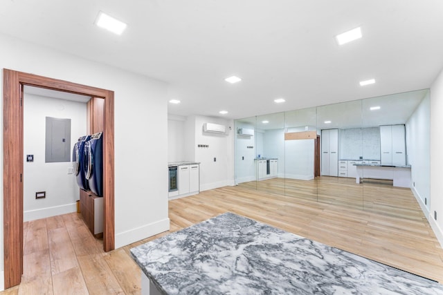 living room featuring a wall unit AC, recessed lighting, baseboards, an AC wall unit, and light wood finished floors