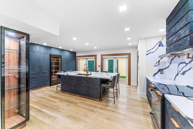 kitchen featuring a sink, range with electric cooktop, modern cabinets, and a breakfast bar area