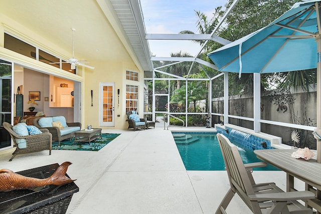 view of swimming pool featuring glass enclosure, a patio, and a ceiling fan