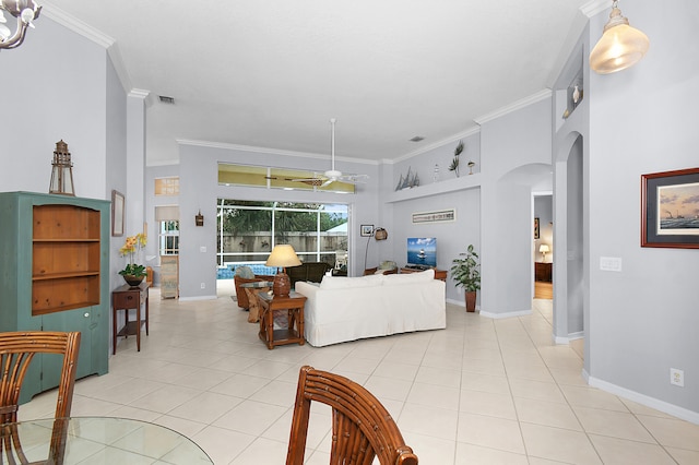 living area featuring crown molding, a high ceiling, light tile patterned floors, and arched walkways