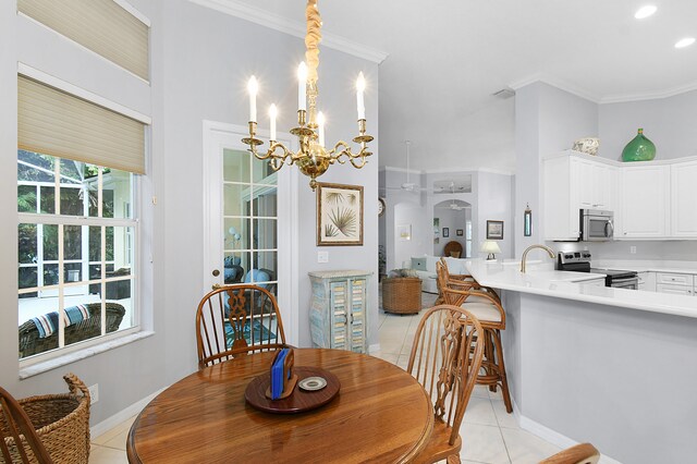 dining room with light tile patterned floors, a notable chandelier, baseboards, and ornamental molding