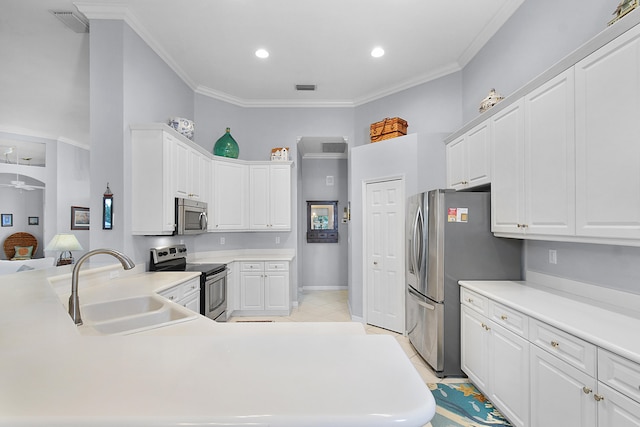 kitchen with white cabinets, stainless steel appliances, crown molding, and a sink